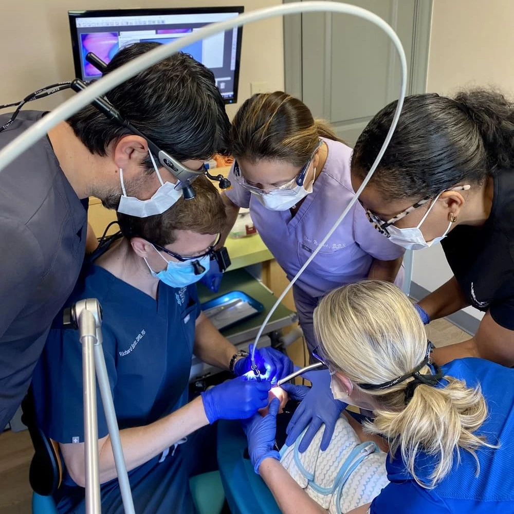 Dr Baxter performing the tongue tie release procedure, while other doctors are watching