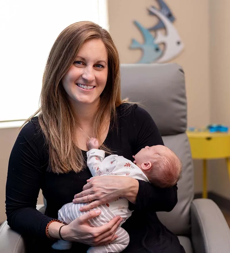 tongue-tie-education-support-homepage-parent Mom holding a baby in her arms at the tongue tie center